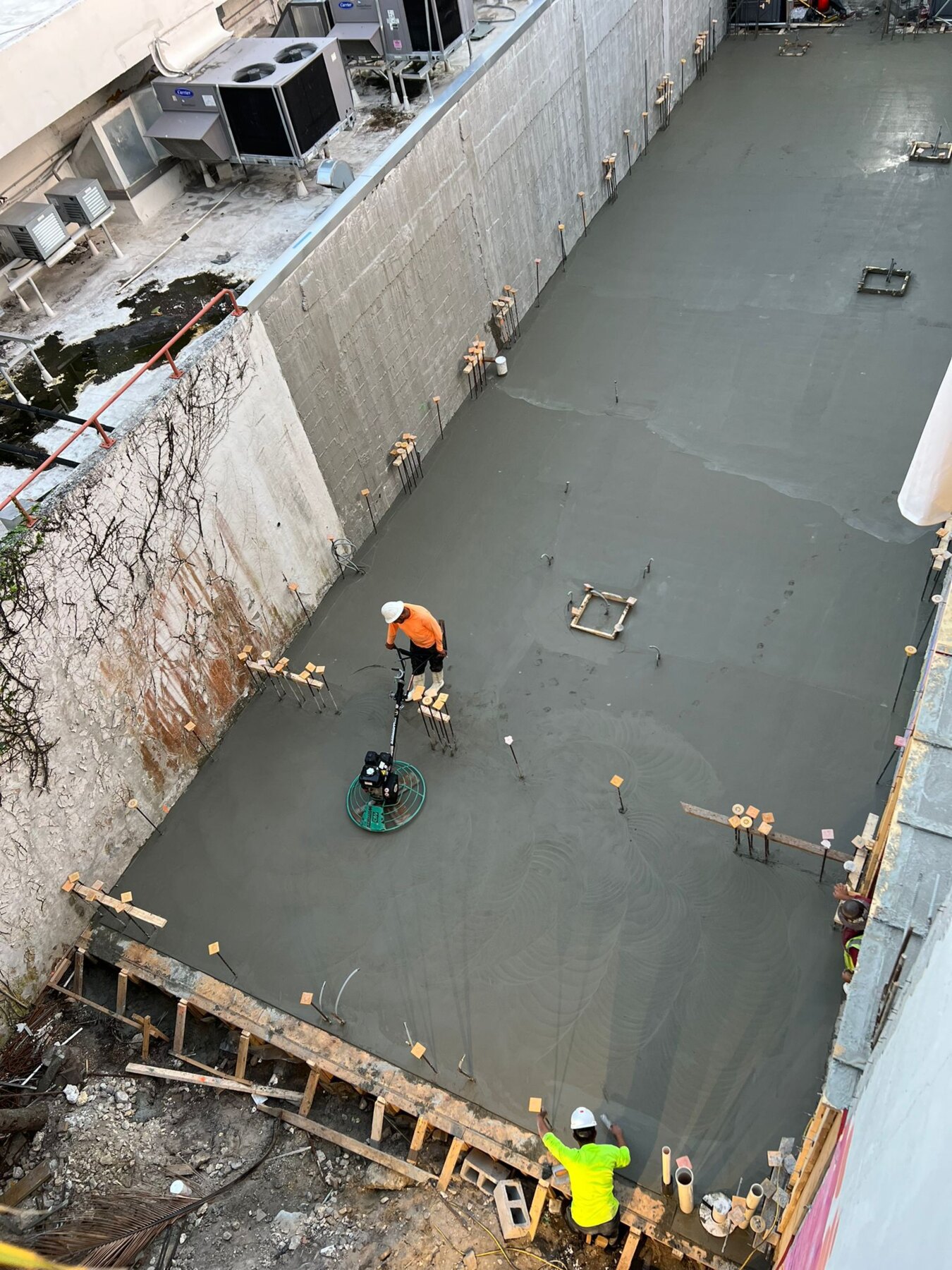 Crew power-trowel finishing a concrete slab
